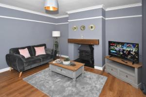 a living room with a couch and a fireplace at Orion House - sleeps 6, driveway, garden in Crewe +28 photos
