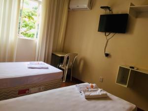 a hotel room with two beds and a window at Hotel GMatos Belo Horizonte - Próximo a Rodoviária e Mercados Turísticos in Belo Horizonte
