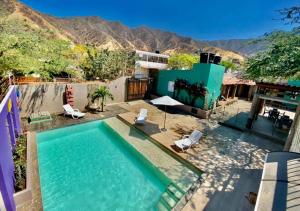 a swimming pool with chairs and a house at Hostal Aurora, Smith Lodging in Taganga