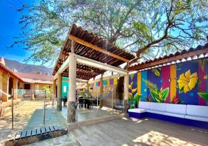 an outdoor area with a pool, benches, and a tree at Hostal Aurora, Smith Lodging in Taganga