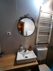 a bathroom with a sink and a mirror and a toilet at Apartment Dea in Kolašin