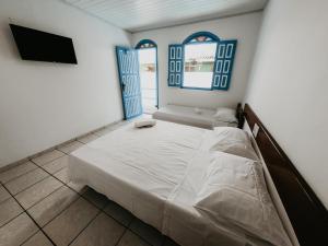 En eller flere senge i et værelse på Pousada Aluá