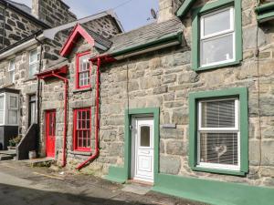 a stone house with red and green doors and windows at Edrydd in Harlech