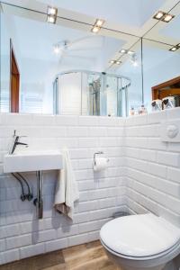 a white bathroom with a toilet and a sink at Apartament Matilena in Świnoujście