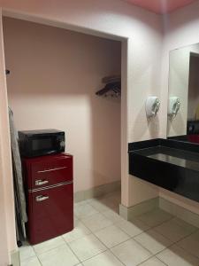 a bathroom with a sink and a television on a red cabinet at Raintree Inn and Suites in Houston