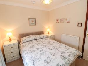 a bedroom with a bed with two night stands and two lamps at Lavender Cottage in Richmond