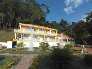 a yellow and white house with a fountain at Hotel Villa San Cayetano in Nocaima