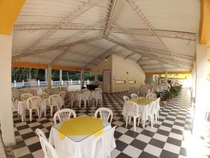 a restaurant with white tables and chairs on a checkered floor at Hotel Villa San Cayetano in Nocaima