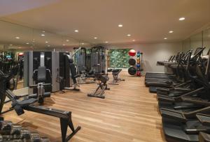 a gym with rows of tread machines and mirrors at The Beverly Hills Hotel - Dorchester Collection in Los Angeles