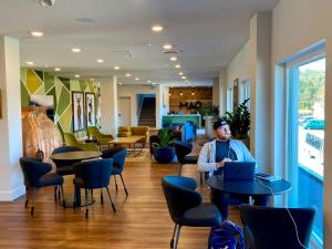 um homem sentado numa mesa com um laptop em The Maq Hotel em Tofino