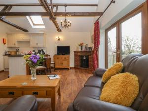 a living room with a couch and a table at Orchard Cottage in Watchet