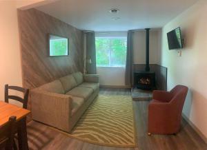 Green Mountain Cabins في كيلنغتون: غرفة معيشة مع أريكة ومدفأة