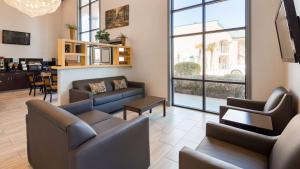 a living room with two couches and a table at SureStay Plus Hotel by Best Western Hammond in Hammond