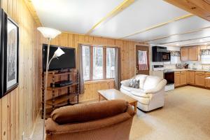 ein Wohnzimmer mit einem Sofa, einem Stuhl und einem TV in der Unterkunft Quaint Lake Escape in Eagle River