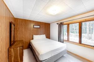 a bedroom with a bed and a window at Quaint Lake Escape in Eagle River