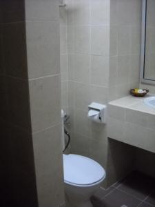 y baño con aseo y lavamanos. en Hotel Seri Malaysia Port Dickson, en Port Dickson