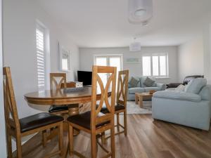 a living room with a table and chairs and a couch at The Sand Dunes in Crantock