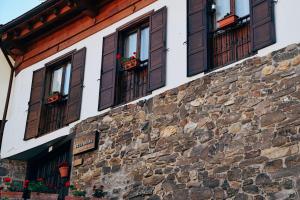 a building with brown windows and a stone wall at Villa Solana in Potes