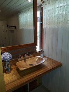 a bathroom with a sink and a mirror at Pousada Casa da Vista in Visconde De Maua +30 photos