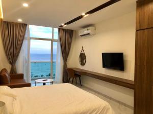 a hotel room with a bed and a tv and a window at Sealiks Ocean vita muine C326 in Phan Thiet