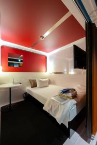 a room with a bed and a table and a tv at Torifito Hotel & Pod Kanazawa in Kanazawa