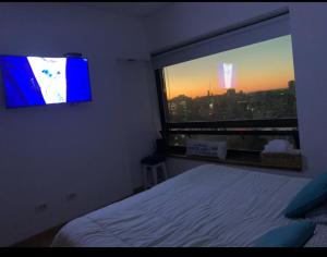 a bedroom with a bed and a window with a television at Buenos Aires View - Apart 2 Amb sobre Av Corrientes in Buenos Aires