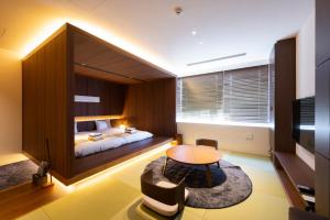 a bedroom with a bed and a table in a room at Torifito Hotel & Pod Kanazawa in Kanazawa