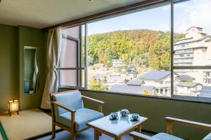 松江市にある玉造温泉 松乃湯の大きな窓とテーブルと椅子のある部屋
