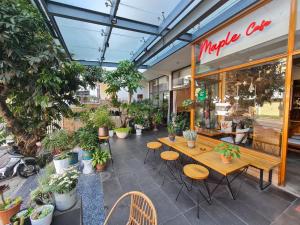 a cafe with tables and chairs and potted plants at Ngan Hoa - Mille Fleurs in Da Lat