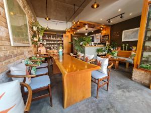 a restaurant with a large wooden table and chairs at Ngan Hoa - Mille Fleurs in Da Lat