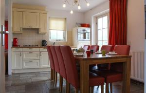 een keuken met een houten tafel en rode stoelen bij Buitengoed Het Lageveld - 58 in Hoge-Hexel
