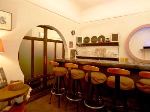 un bar con taburetes en una habitación con ventana en Takeyaso Ryokan, en Amagasaki