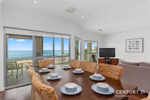 a living room with a table and chairs and a couch at Percival Point - Port Willunga - C21 SouthCoast Holidays in Port Willunga