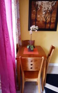a wooden table and chair with a vase of flowers on it at Poolside Mystic Apt 9A in Ocho Rios