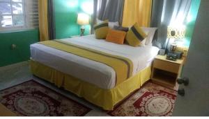 a bedroom with a large bed with yellow and green at Poolside Mystic Apt 9A in Ocho Rios +24 photos