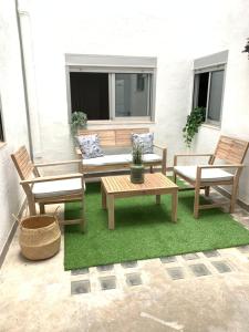 un patio avec deux chaises, une table et un banc dans l'établissement UIM Mediterraneo Buenavista Wifi, à Puerto de Sagunto