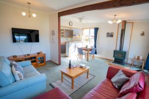uma sala de estar com um sofá e uma mesa em Dee's on Bligh - Te Anau Holiday Home em Te Anau