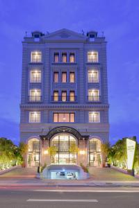 a tall blue building with lights on at Grand Senyum Hotel, Tugu Yogyakarta in Yogyakarta