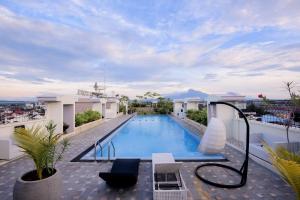 a swimming pool on the roof of a building at Grand Senyum Hotel, Tugu Yogyakarta in Yogyakarta