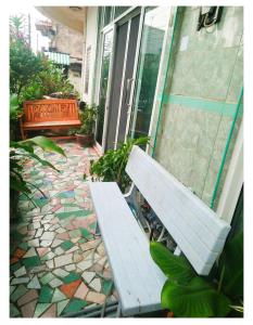a white bench sitting on a patio next to a building at whole house for 5 guests 3 beds in Hat Yai