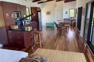 a living room with a kitchen and a dining room at Ridge Cabin - Stunning Views - 5km From Neighbours in Airlie Beach