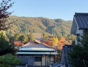 a building with a mountain in the background at Munetada House in Kyoto