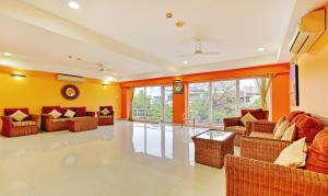 a living room filled with furniture and a large window at Treebo Trend Vapr Guindy Ekkatuthangal in Chennai