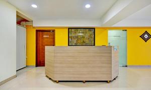 a reception desk in a room with yellow walls at Treebo Trend Vapr Guindy Ekkatuthangal in Chennai