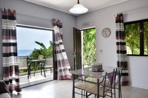 a dining room with a table and chairs and a balcony at Bousounis Apartments in Chrani