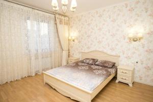 a bedroom with a bed in a room with pink wallpaper at Provence Deribasivska Apartment in Odesa