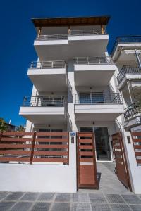 Edificio blanco con 2 balcones y 2 puertas en Novelrooms, en Paralia Katerinis