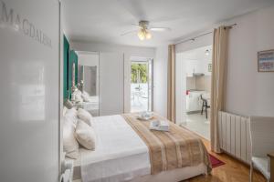 a white bedroom with a bed and a bathroom at Apartments Villa Katana in Poreč