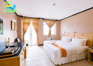 a hotel room with a bed and a desk at Vista Mar Beach Resort and Country Club in Mactan