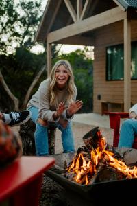 a woman is standing next to a fire at Lucky Arrow Retreat in Dripping Springs